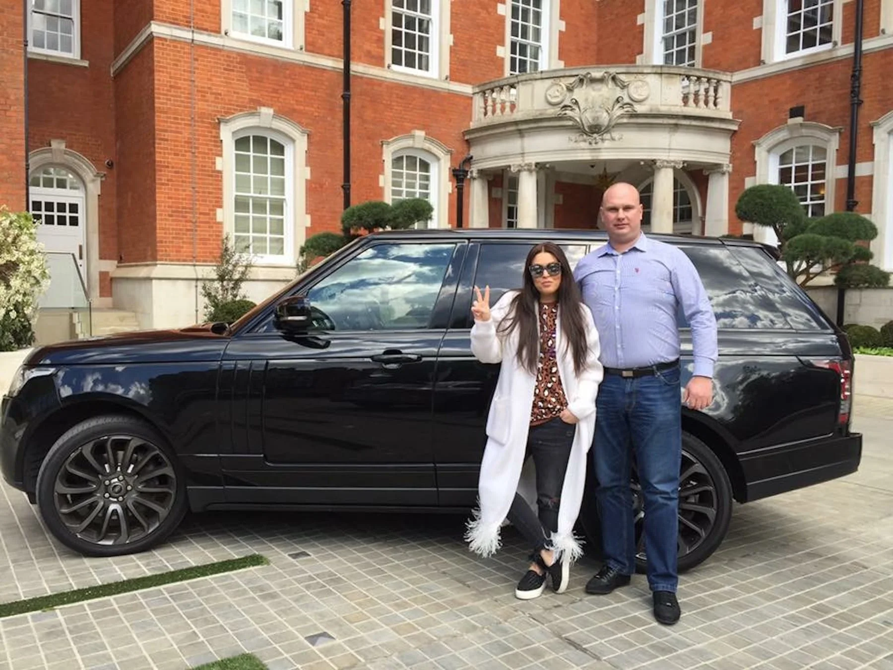 Bodyguard with a client beside a black SUV
