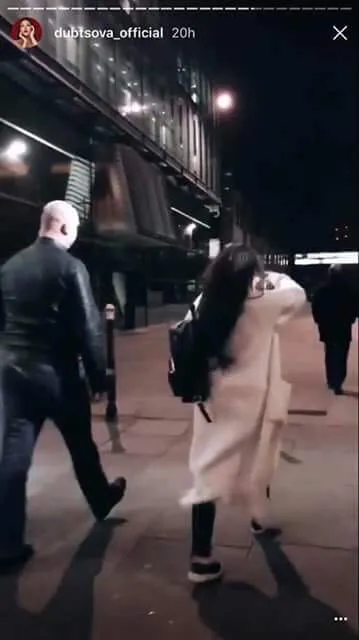 Close protection officer escorting a client through a city at night