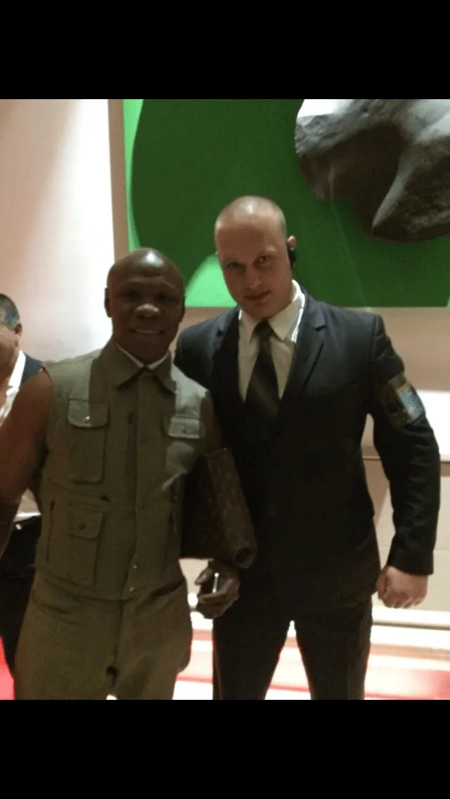 Close protection officer wearing an earpiece with a guest at an event venue