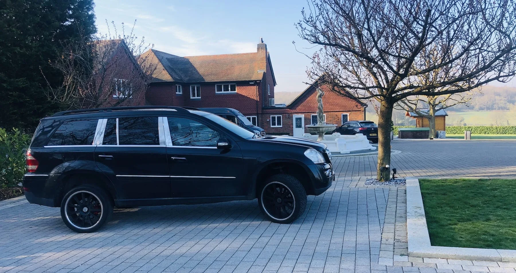 Black security vehicle outside a country estate