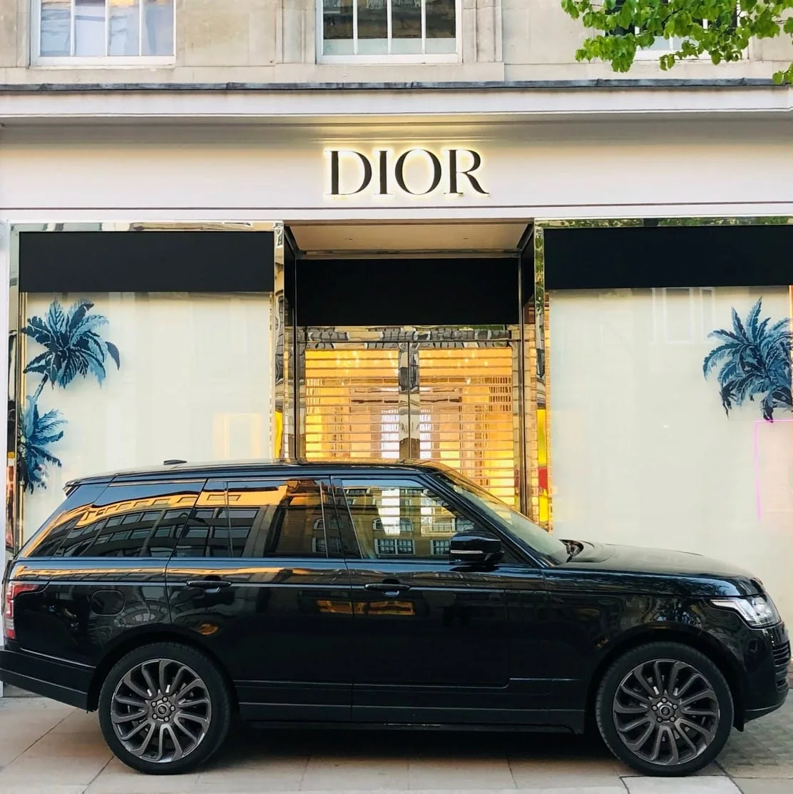 Black security vehicle outside a luxury retail store