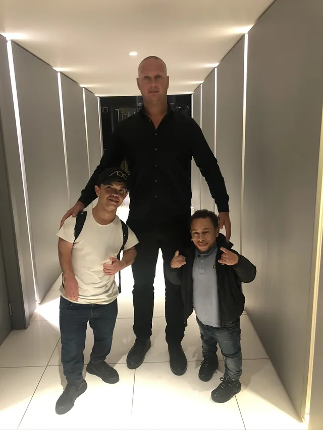 Security professional with two guests in an indoor corridor